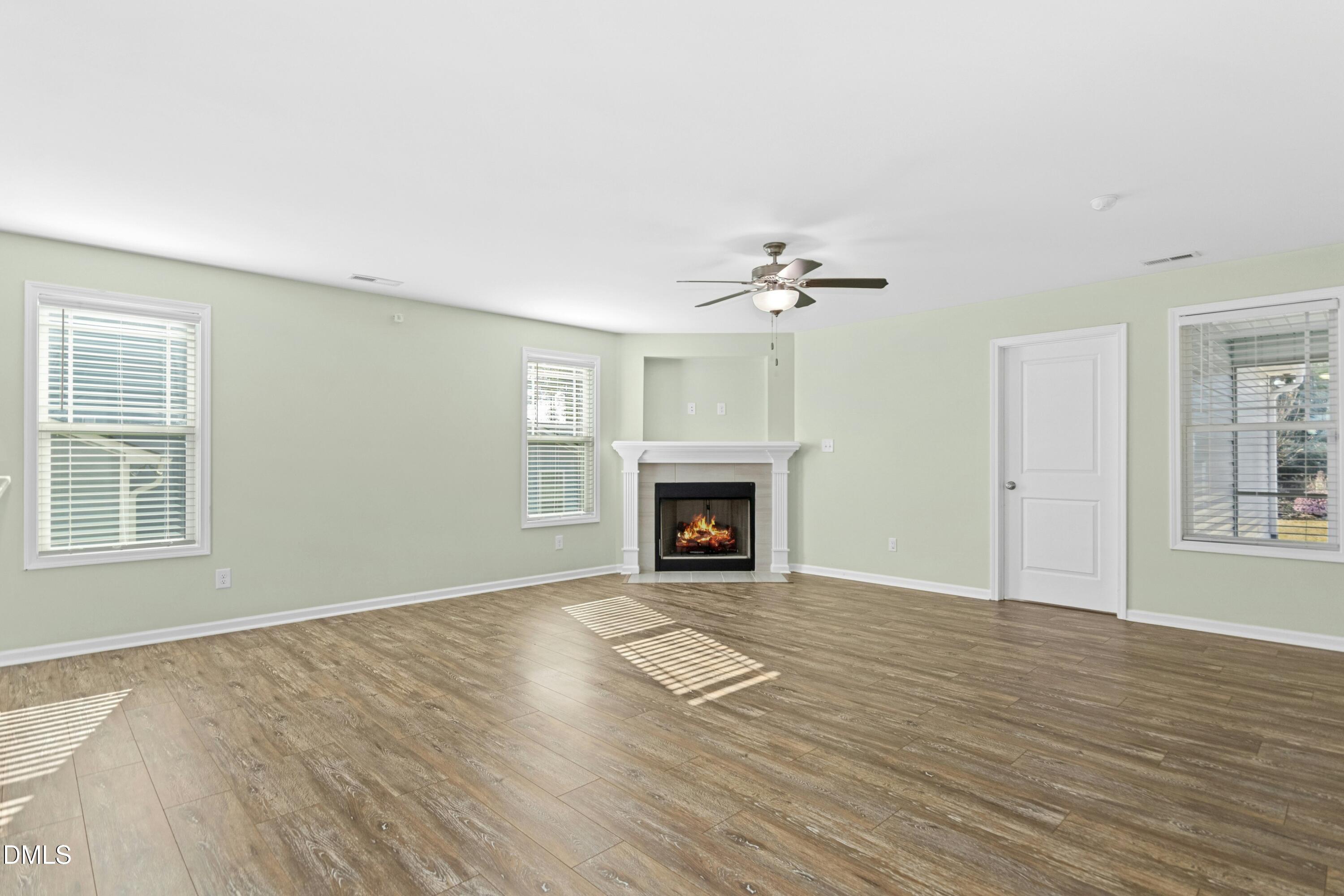 48 Mountain View Drive Garner, NC 27529 - Photo 9 of 29 a view of an empty room with wooden floor fireplace and a window