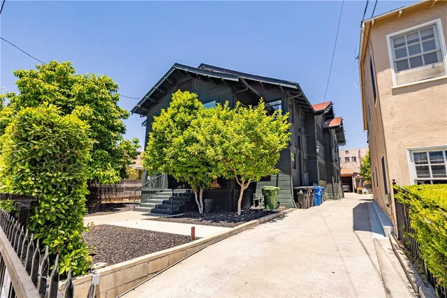 a view of a yard with plants and wooden fence