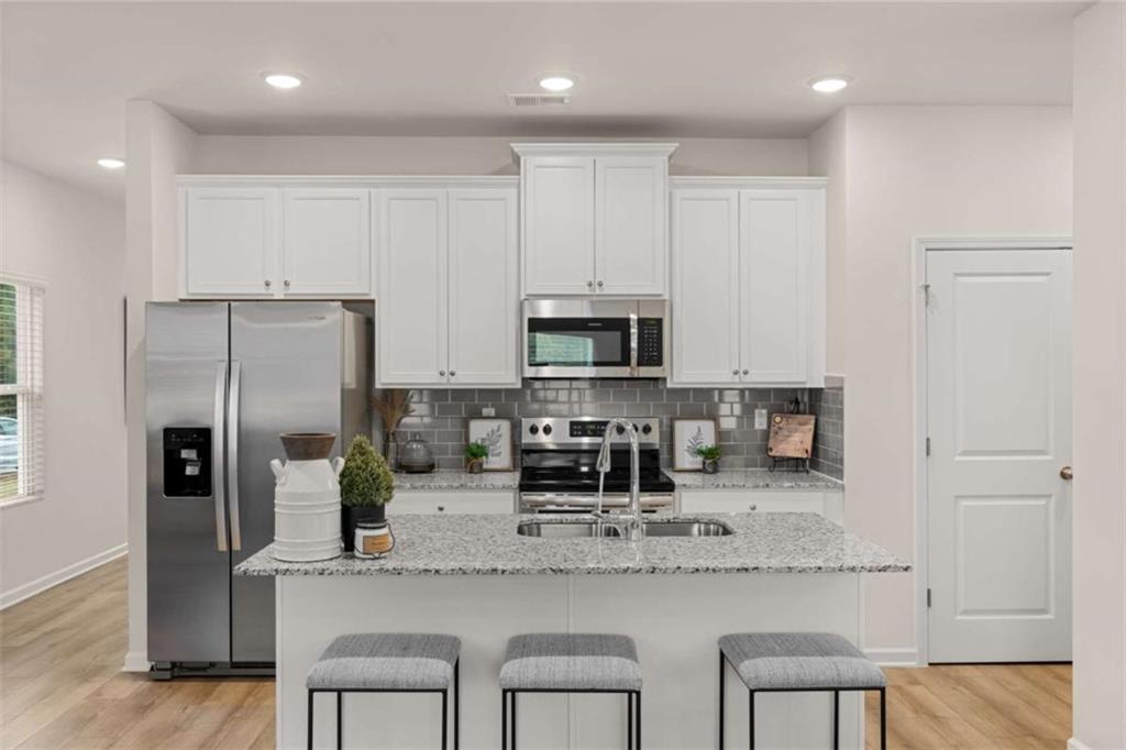 1057 Merritt Drive, Unit 83 Villa Rica, GA 30180 - Photo 4 of 49 a kitchen with stainless steel appliances granite countertop a sink refrigerator and cabinets