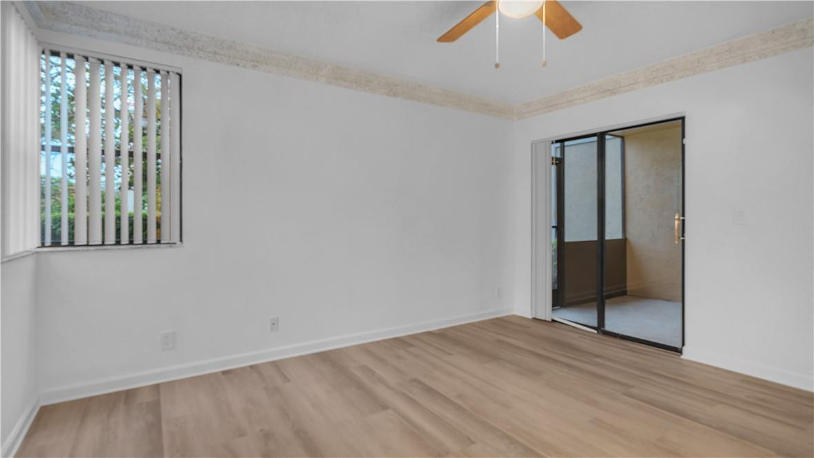 5681 Riverside Drive, Unit 101A6 Coral Springs, FL 33067 - Photo 13 of 25 a view of an empty room with wooden floor and a window