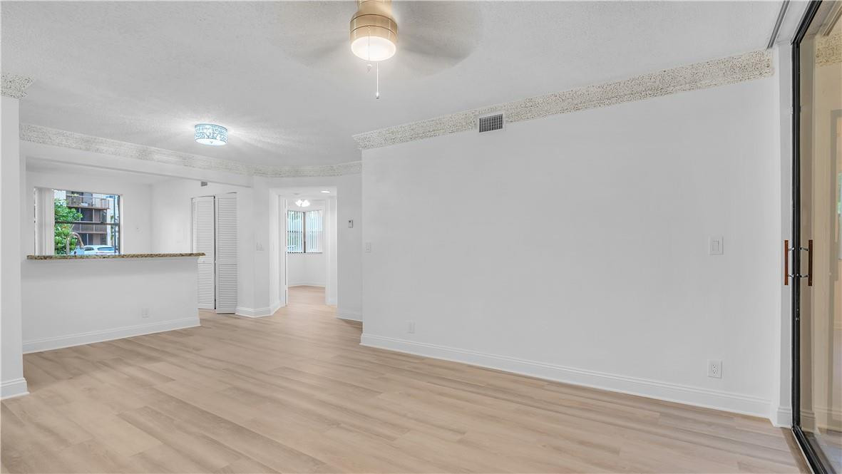 5681 Riverside Drive, Unit 101A6 Coral Springs, FL 33067 - Photo 6 of 25 a view of an empty room with wooden floor and a window