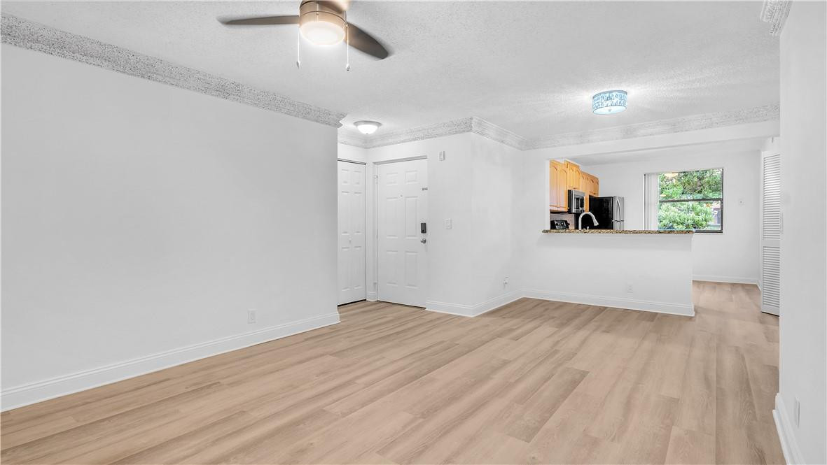 5681 Riverside Drive, Unit 101A6 Coral Springs, FL 33067 - Photo 7 of 25 wooden floor in an empty room with a window