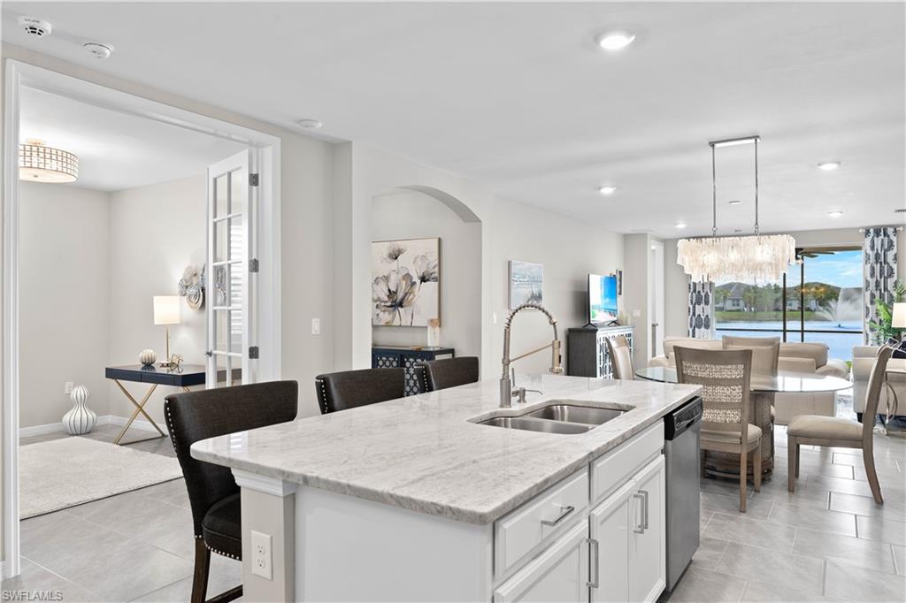 14558 Edgewater Circle Naples, FL 34114 - Photo 5 of 40 a kitchen with a table chairs and white cabinets
