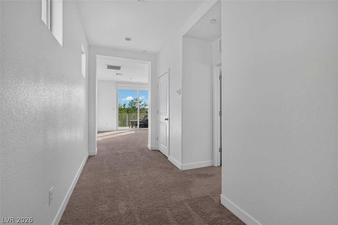 1100 East Sunset Road Henderson, NV 89011 - Photo 30 of 58 A well-lit corridor provides access to rooms and a private balcony overlooking verdant trees.