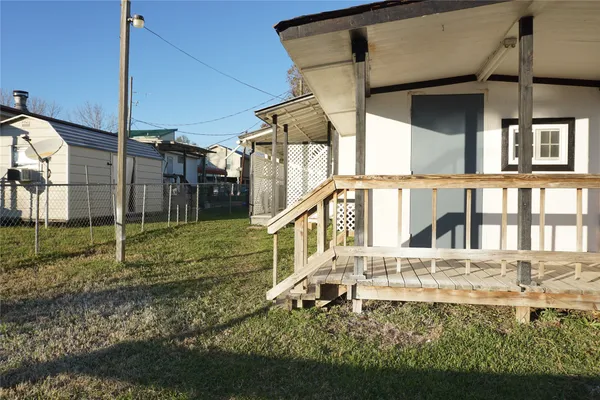 a view of a lake with a yard and large trees