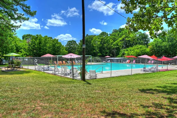 a view of swimming pool with lake and trees in the background