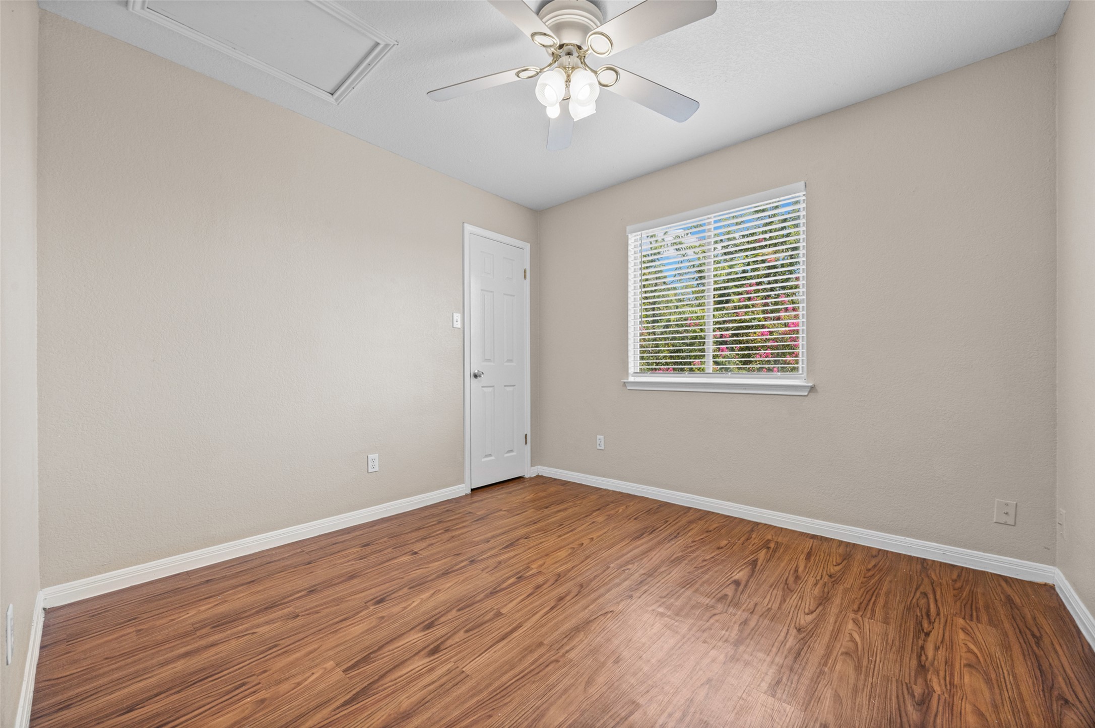 2432 Roundabout Lane Round Rock, TX 78664 - Photo 18 of 22 A quiet retreat, this bedroom offers durable wood flooring and ample natural light from a well-placed window.