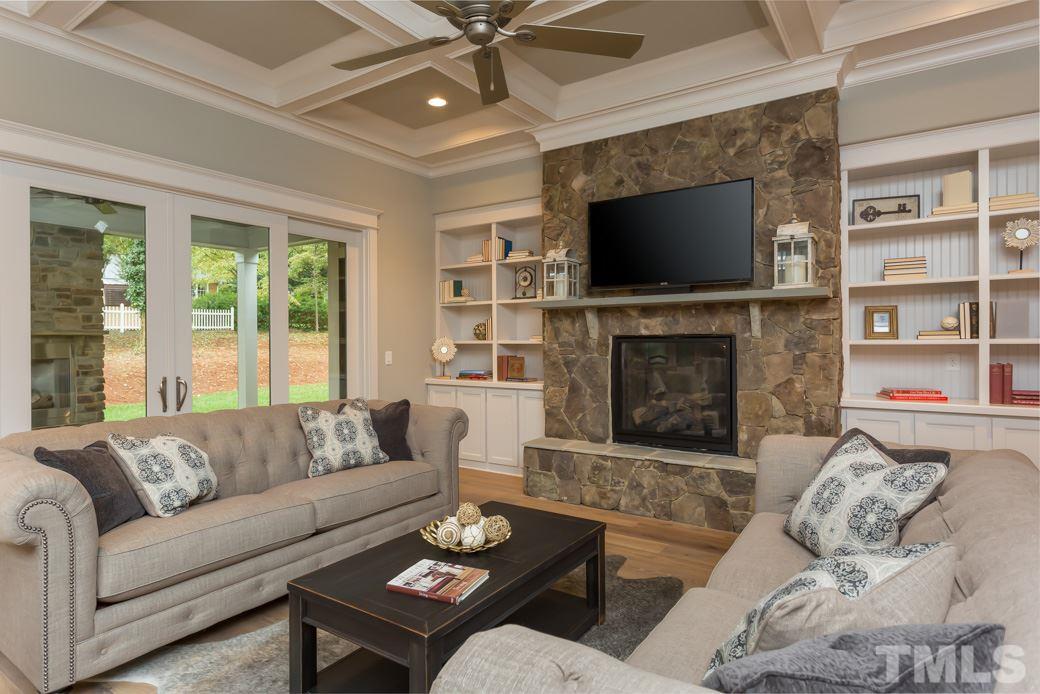 3208 Cobblestone Court Raleigh, NC 27607 - Photo 4 of 25 a living room with furniture a flat screen tv and a fireplace