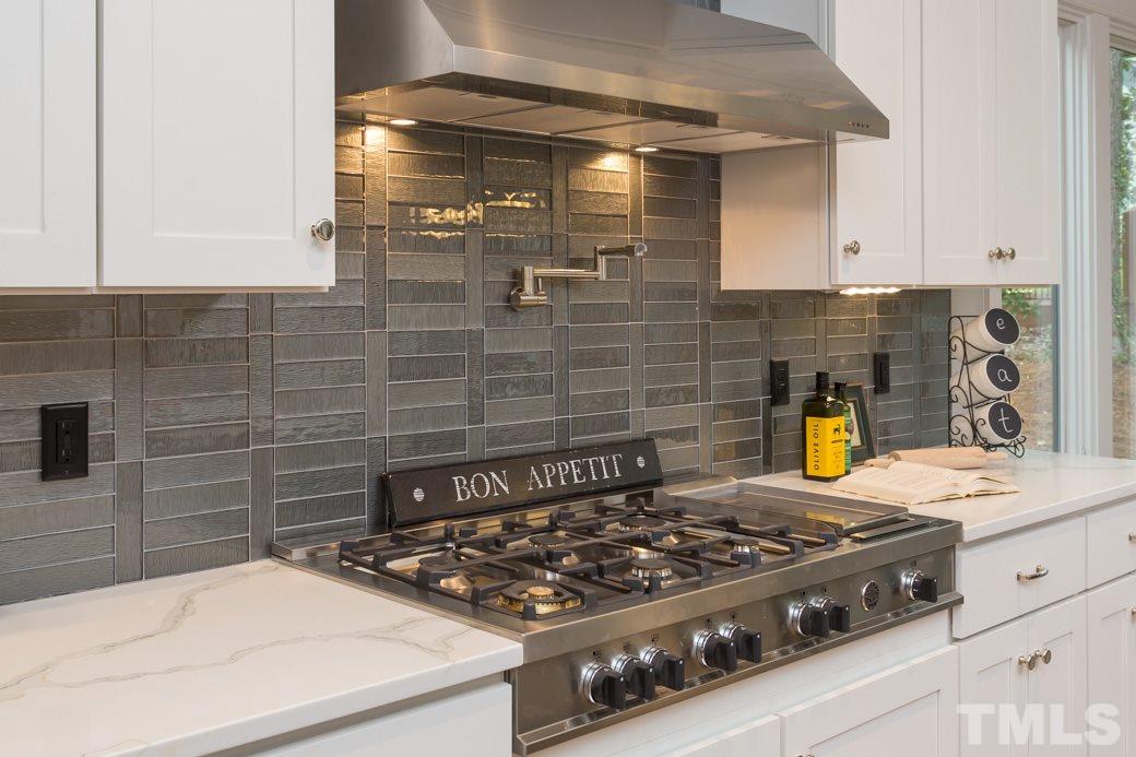 3208 Cobblestone Court Raleigh, NC 27607 - Photo 8 of 25 a kitchen with a stove and white cabinets