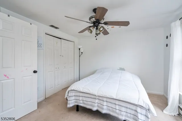 a bedroom with a bed and ceiling fan