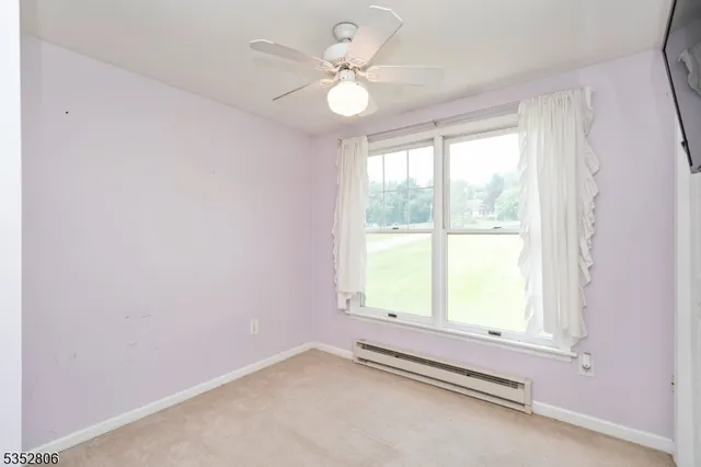 an empty room with window and ceiling fan