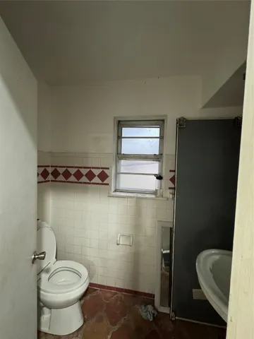 a bathroom with a toilet and a mirror