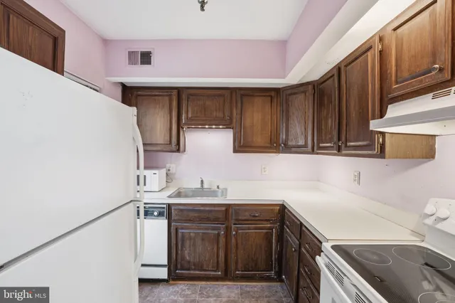 a kitchen with a sink a stove and cabinets