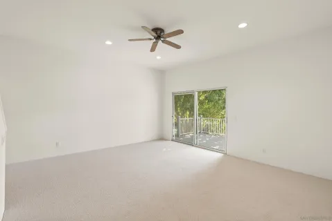 an empty room with a ceiling fan and windows