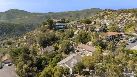 an aerial view of residential house with parking and mountain view