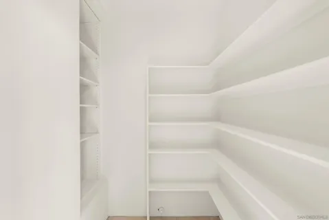 a view of walk in closet with empty racks