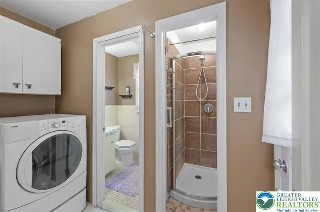 a bathroom with a washing machine and a shower
