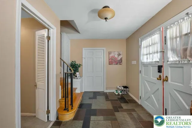 a view of a hallway with a livingroom and a chandelier