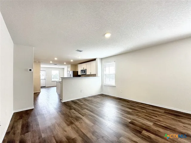 a view of kitchen and hall with wooden floor