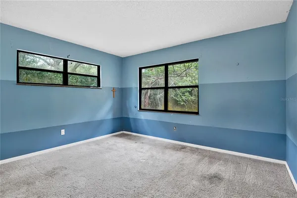an empty room with windows and closet