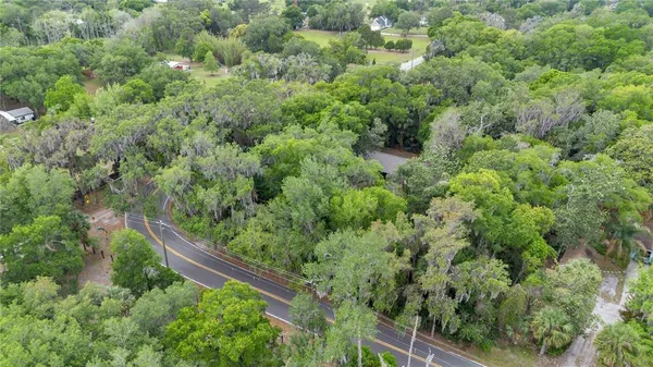 an aerial view of residential house with outdoor space and trees all around
