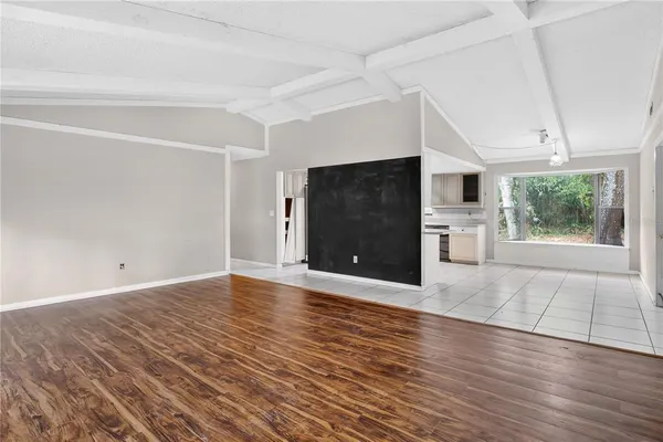 a view of a hallway with wooden floor and a living room