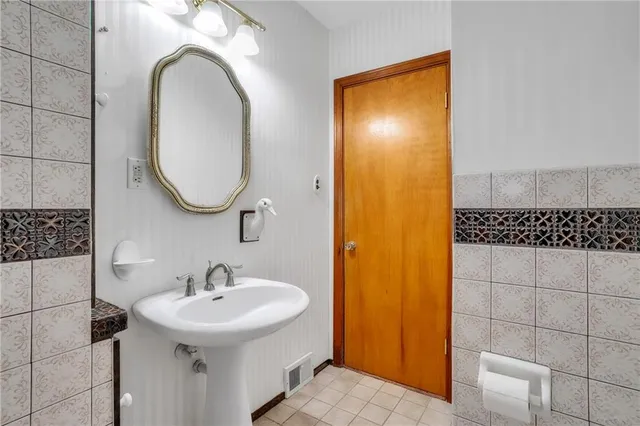a bathroom with a sink a toilet and a mirror
