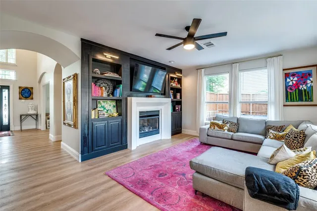 a living room with furniture a fireplace and a large window