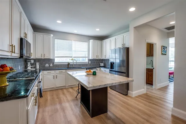 a kitchen with stainless steel appliances granite countertop refrigerator sink stove and oven