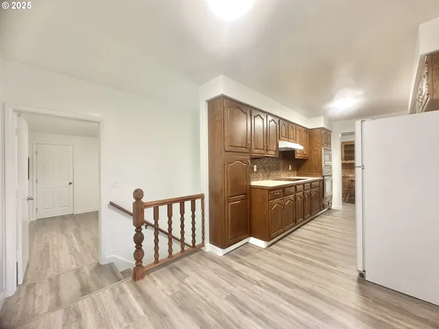 a kitchen with granite countertop a refrigerator and a sink