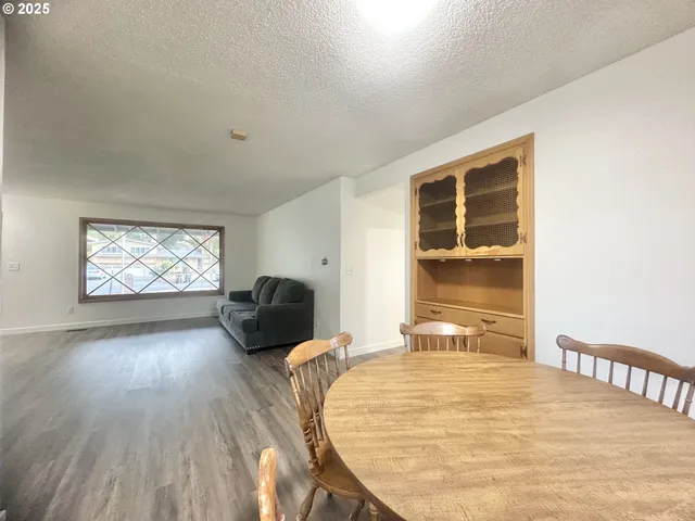 a bedroom with wooden floor and window