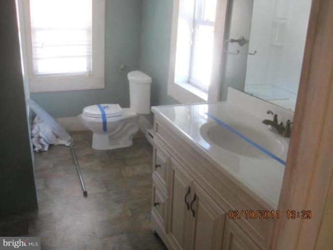 1335 Bruceville Road Keymar, MD 21757 - Photo 14 of 16 a bathroom with a granite countertop sink a toilet and a window