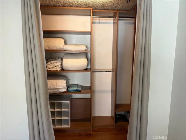 a view of a walk in closet and wooden floor