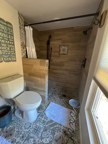 a bathroom with a toilet and a shower