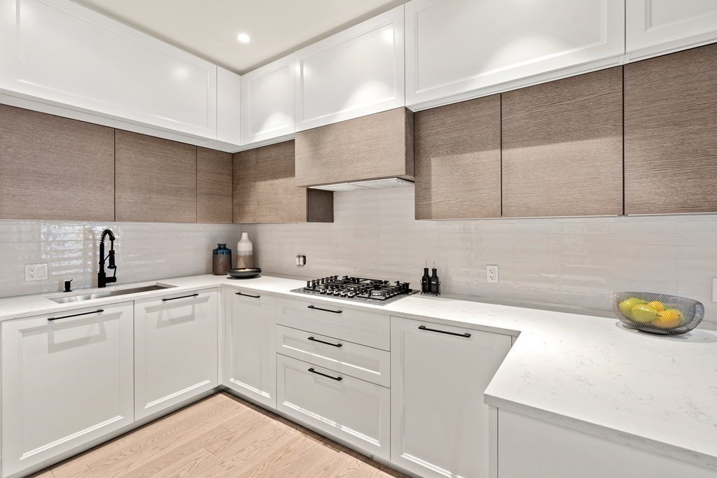 a kitchen with a sink a stove and cabinets