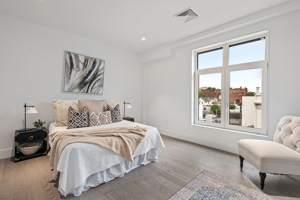 69 Walnut Street, Unit 15 Brookline, MA 02445 - Photo 5 of 21 a bedroom with a bed and a large window