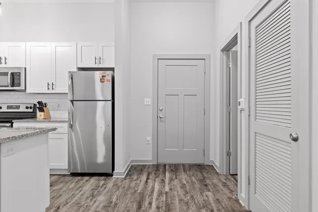 a view of a kitchen with a refrigerator a stove top oven and cabinets
