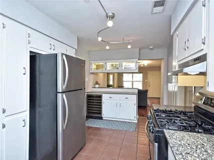a kitchen with a refrigerator a sink and cabinets
