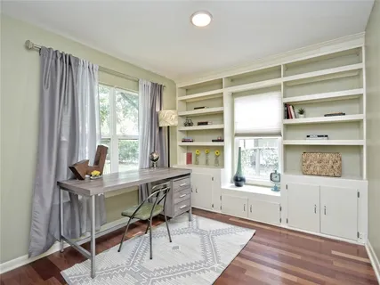 a view of a workspace with furniture and a window