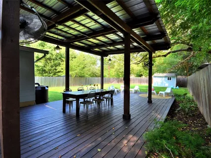 a view of a patio with table and chairs potted plants with wooden floor and fence
