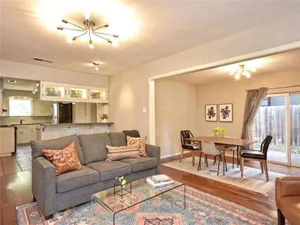a living room with furniture and a view of kitchen