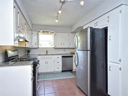 a kitchen with a refrigerator sink stove and cabinets