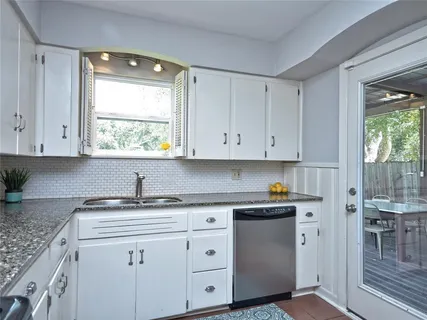 a kitchen with white cabinets and white appliances