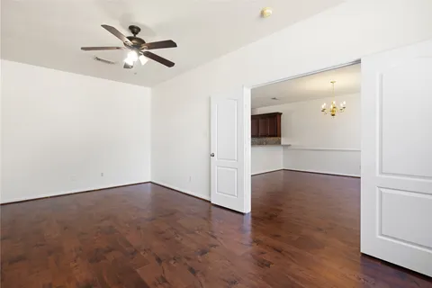 an empty room with wooden floor and mirror