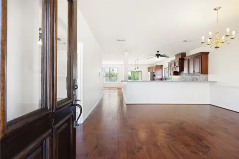 a view of a living room and a kitchen with wooden floor