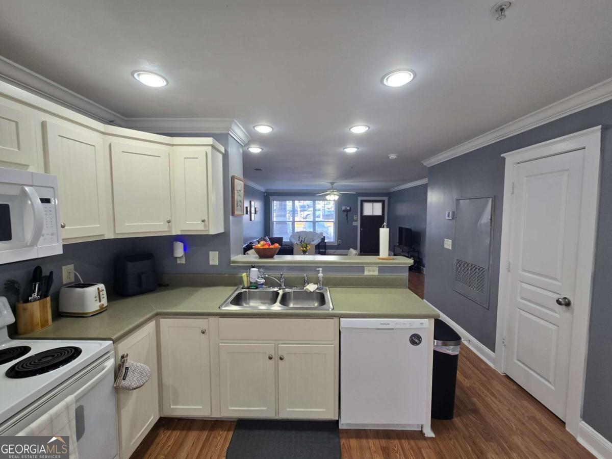 490 Barnett Shoals Road, Unit 205 Athens, GA 30605 - Photo 11 of 19 a kitchen with kitchen island granite countertop a sink cabinets and wooden floor
