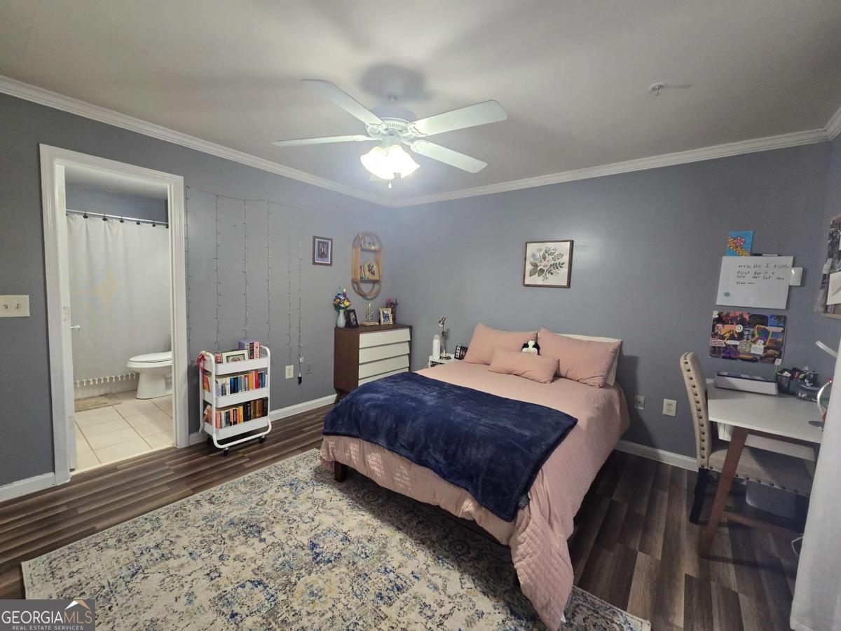 490 Barnett Shoals Road, Unit 205 Athens, GA 30605 - Photo 18 of 19 a bedroom with a bed and wooden floor