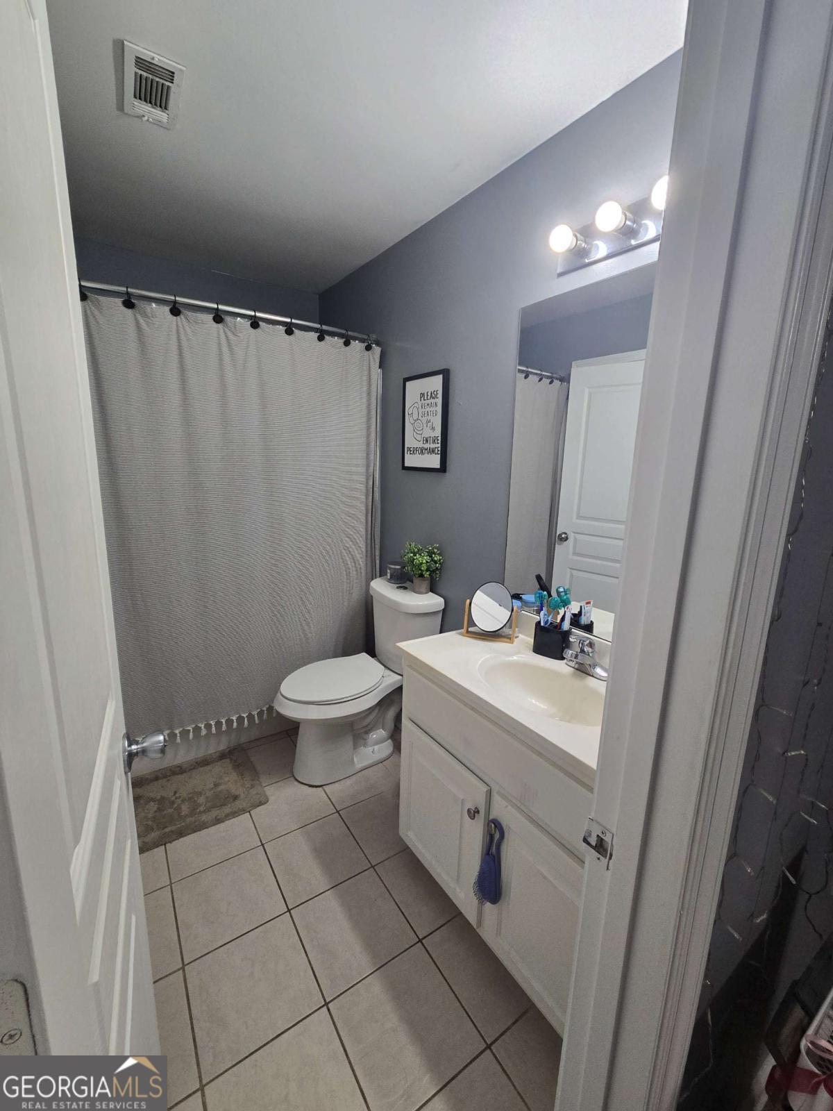 490 Barnett Shoals Road, Unit 205 Athens, GA 30605 - Photo 19 of 19 a bathroom with a sink a toilet a mirror and shower curtain
