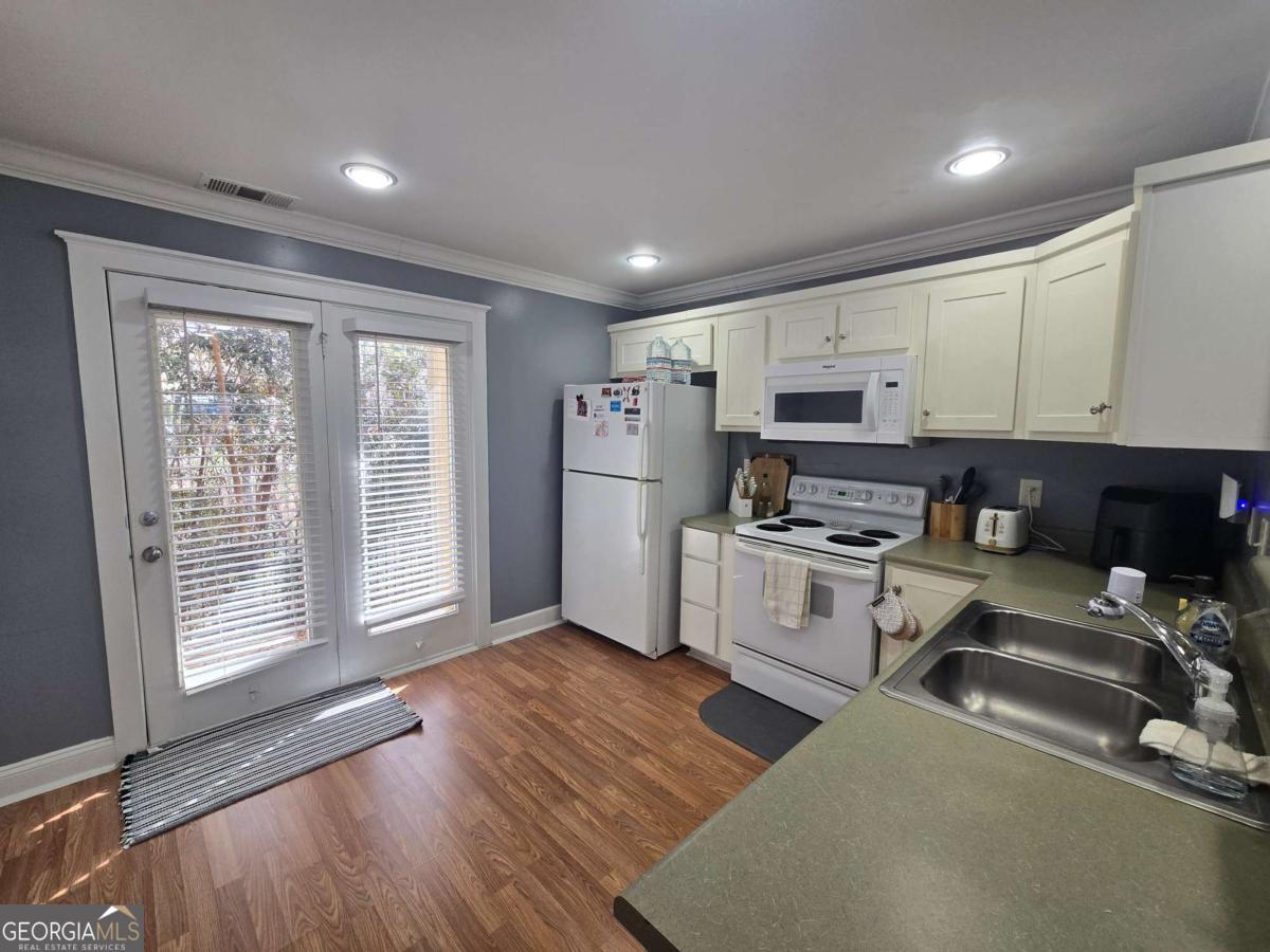 490 Barnett Shoals Road, Unit 205 Athens, GA 30605 - Photo 9 of 19 a kitchen with stainless steel appliances granite countertop a stove a sink and a refrigerator