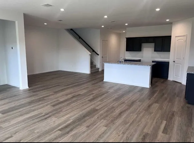 an open kitchen view with wooden floor and a fireplace
